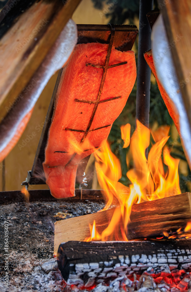 Φωτογραφία Flame grilled salmon cooks over wood fire, Zurich Christmas market, Switzerland