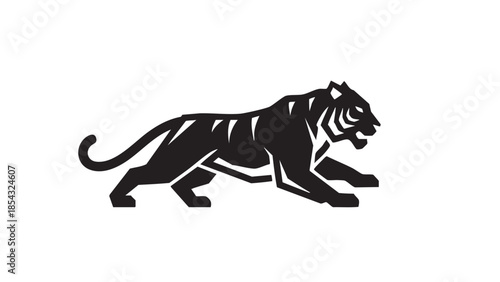 A majestic tiger crouches in a hunting stance, ready to pounce in a serene forest landscape.