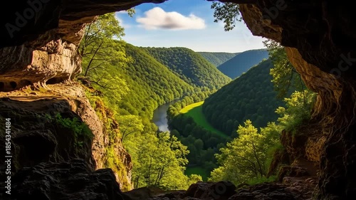 A scenic view of a river valley seen from inside a cave, a natural wonder.