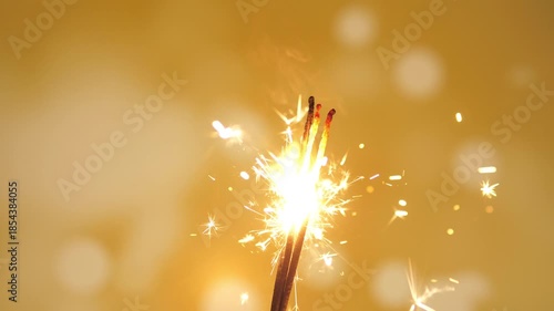 Holiday Christmas New Year or birthday joy sparkler on a yellow background