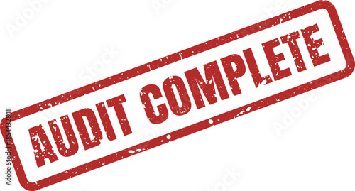A vibrant red textured rubber stamp with the phrase AUDIT COMPLETE clearly visible on a white surface