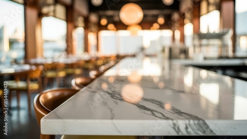 Blurred restaurant interior with a focus on a marble bar counter and brown bar stools