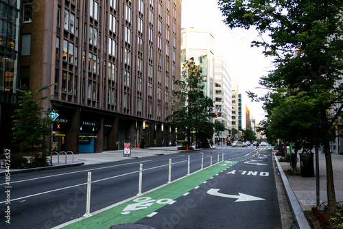 Protected urban bike lane along city street with bollards and cycling arrows. g.
