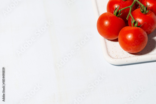 juicy ripe cherry tomatoes on a branch, white background, top view