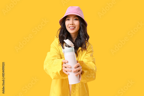 Young Asian woman in rainco...