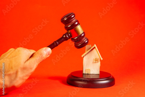 wooden gavel in hand of judge on orange background. law concept