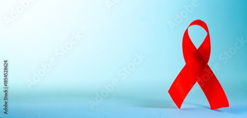 Red ribbon on blue background with copy space. World Aids Day concept.