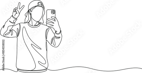 Young person wearing a baseball cap takes a selfie with a smartphone