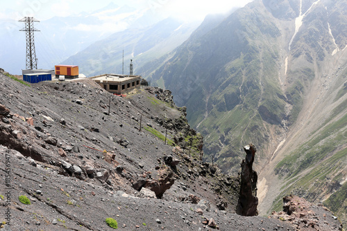 Rocky mountain landscape with building under construction and power line pylon