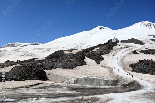Snow-covered mount Elbrus landscape with mountaineers on winding slope
