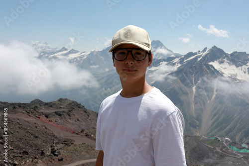 Young boy with cap and glasses against Mount Elbrus landscape