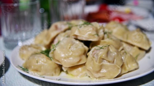 A close-up of freshly cooked manti lying on a plate. Traditional dishes of Central Asia and China.