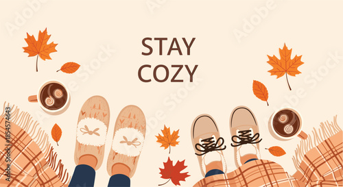 Autumn flat lay composition shows two pairs of feet in cozy slippers and shoes with hot coffee, maple leaves, and a plaid blanket.