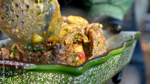 Freshly cooked hot pilaf is served in a ceramic bowl outdoors. A delicious Kazakh ethnic dish. Close-up.