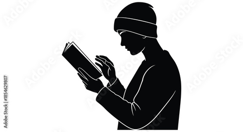 A contemplative reader engrossed in a book captured in a striking black and white silhouette