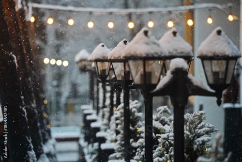 Street lights under a layer of snow.  Snowfall.