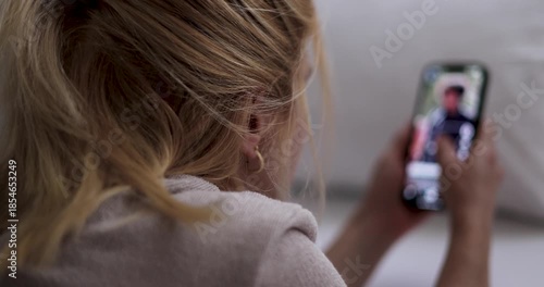 Woman doom scrolling through social media or watching reels. Alone in bedroom, staring at smartphone. emotional distance psychological strain. Smartphone addiction. Digital overload, loneliness.