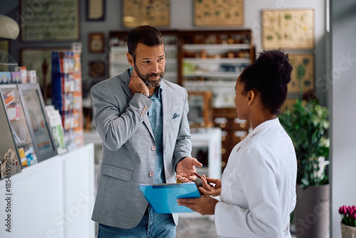 Distraught man talking to his pharmacist in drugstore.
