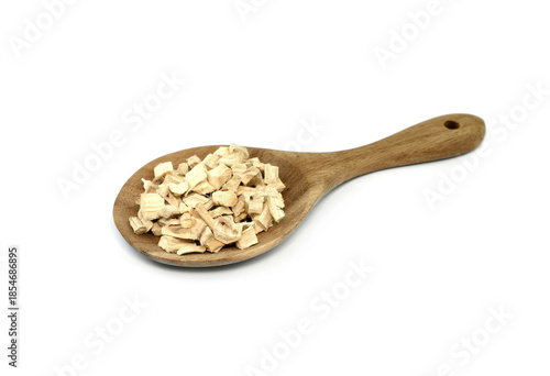Pile of dried and sliced marshmallow root in a wooden spoon (Althaea officinalis) isolated on white background