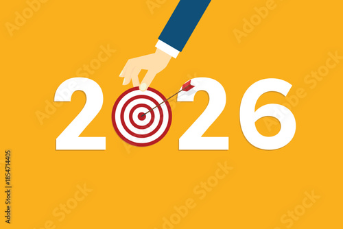 Human hand holding business target for a business year 2026. Red arrow hits target center. Business success concept.