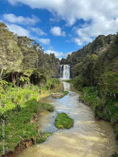 Beautiful view of creek and waterfall with sunny sky.