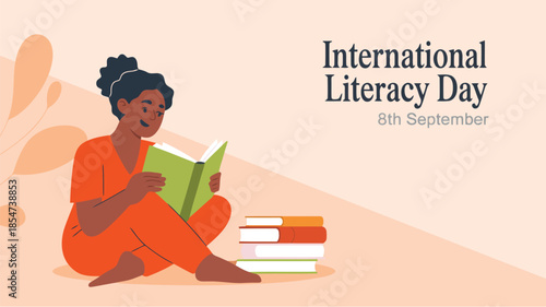 A smiling woman in orange clothes sits reading a book with a stack of literature nearby celebrating International Literacy Day