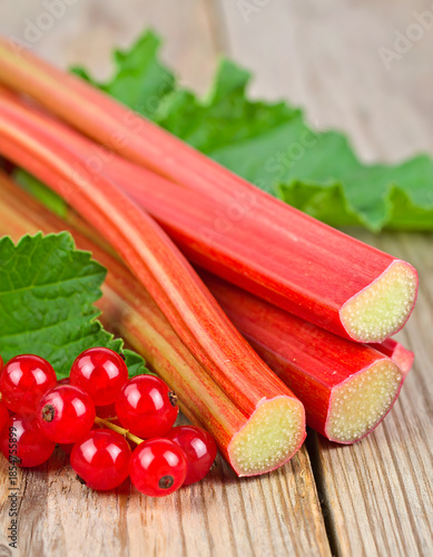 Organic Rhubarb and Redcurrants with Leaves on Wooden Background
