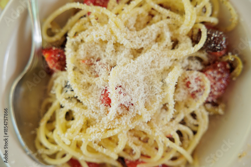 spaghetti con pomodorini a fette, olive e formaggio, visti da sopra, tradizionale piatto leggero estivo italiano, 