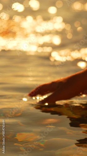 Hand water sunset golden hour touch ripples romantic surface Vertical video
