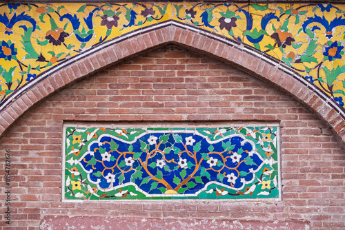 Colorful kashi-kari or faience tile mosaic floral and geometric design on ancient mughal era Wazir Khan mosque in Lahore walled city, Punjab, Pakistan