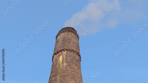 The white smoke is coming out from the chimney with blue sky background, Air pollution by brick kiln chimney, Ancient architecture of Uzbekistan, Registan square, Bibi khanym mosque, Itchan kala old