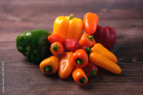 a vibrant collection of colorful bell peppers arranged on a wooden surface, highlighting their rich hues and smooth texture in a rustic kitchen setting, seasonal, palette, plant, vitaminc, juicy