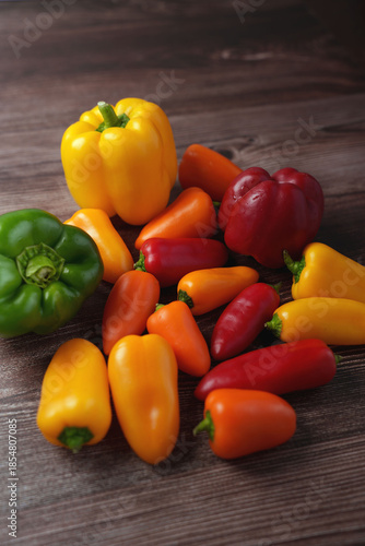 a vibrant assortment of fresh yellow, red, and green bell peppers and mini sweet peppers placed on a rustic wooden table, showcasing a colorful, healthy, and natural food display, elements, visual