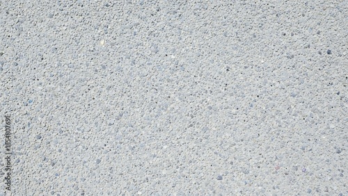 Textured concrete surface, close-up of light gray aggregate and cement background