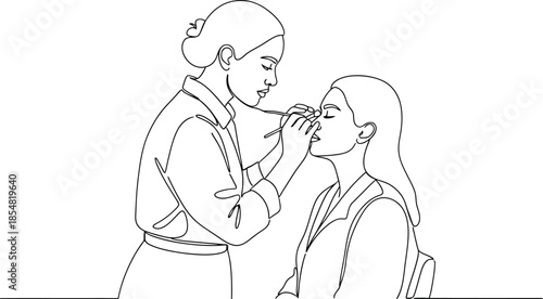 Makeup artist applying makeup to woman's face