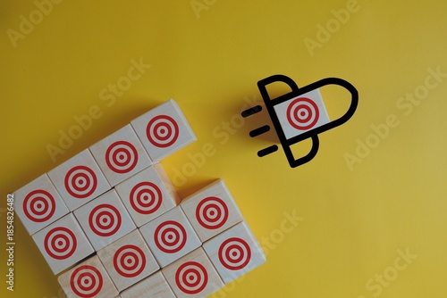 A puzzle with targets on the pieces and a lightbulb outline with a target inside on a yellow background