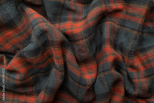 Texture of wrinkled plaid blue green red brown cotton flannel fabric, top view. Tartan pattern, textile for shirt, clothing, tablecloth. Checkered print, Christmas New Year textile pattern