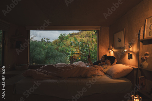 Valokuva Cozy morning in a natural wood cabin as a couple relaxes in bed by a large pictu
