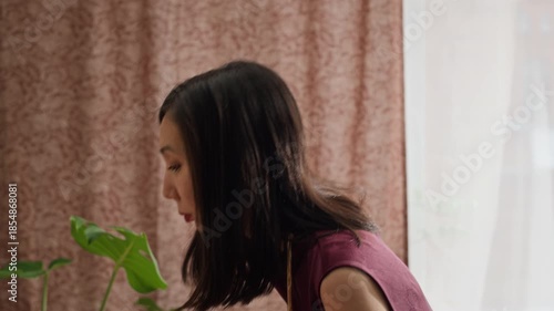 Wallpaper Mural Young Asian dark-haired woman in dress offering prayers by home altar with Buddha figurine, fruits, and flowers during Tet celebration Torontodigital.ca