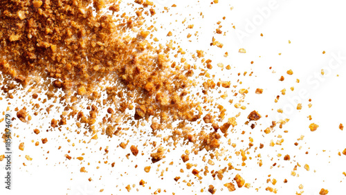 Close-up top view of brown granular sugar or spice crumbs scattered on a clean white background, creating a textured pattern.
