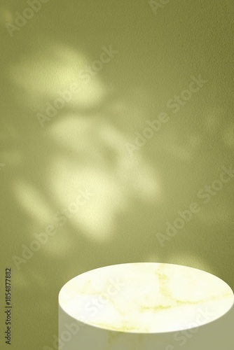 Minimalist Product Display with Leaf Shadows on Yellow Green Wall and Marble Stand.