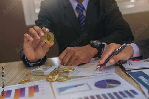 Businessman holding Bitcoin for digital currency trading at his workplace. Bitcoin and digital money concept.
