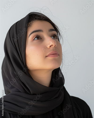 A mysterious Arabic lady with beautiful eyes wears a traditional black hijab and niqab as a religious ethnic fashion statement