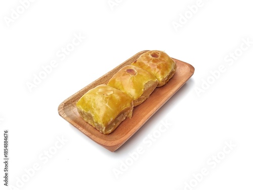 Roti bolen or bolen cake on wooden plate isolated on white background, is a typical Indonesian bread with crispy layers. High angle view