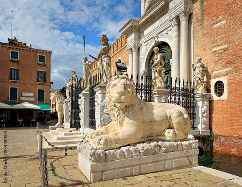 Stone lion and other stone sculptures at Campo de Arsenal in front of the entrance of the venetian Arsenal, Venice, Italy 