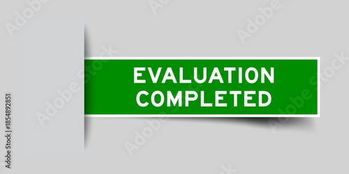 Green color square shape sticker label with word evaluation completed inserted in gray background