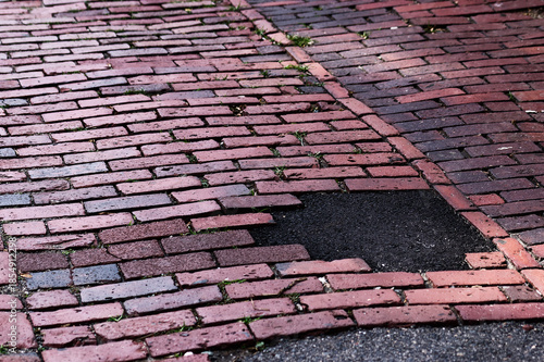Urban Decay: Weathered Brick Pavement With Asphalt Repair Patch, Moss Growing Vertical Shot