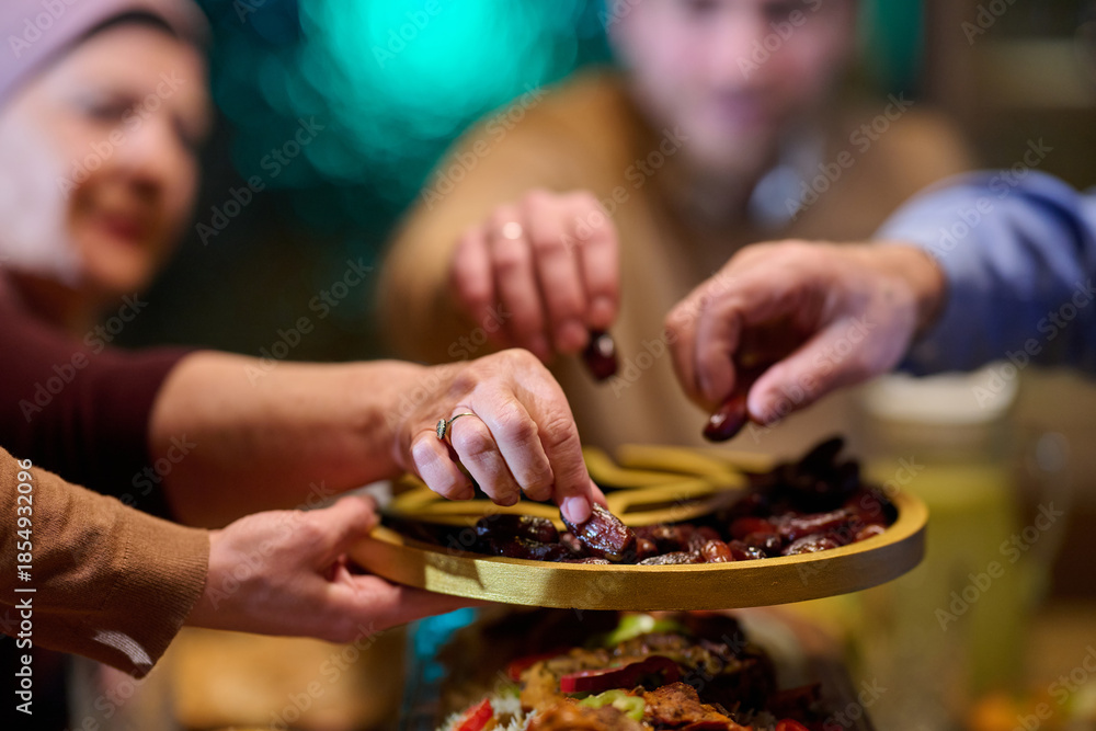 Fototapeta premium Gathering around a table to share dates during iftar in a home filled with Ramadan spirit and family bonds