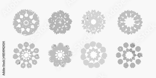 An arrangement of eight circular snowflake like patterns in grayscale tones