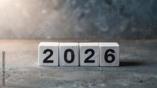 コンクリートの質感を背景に白い2026キューブを並べ、編集寄りの落ち着いた印象に